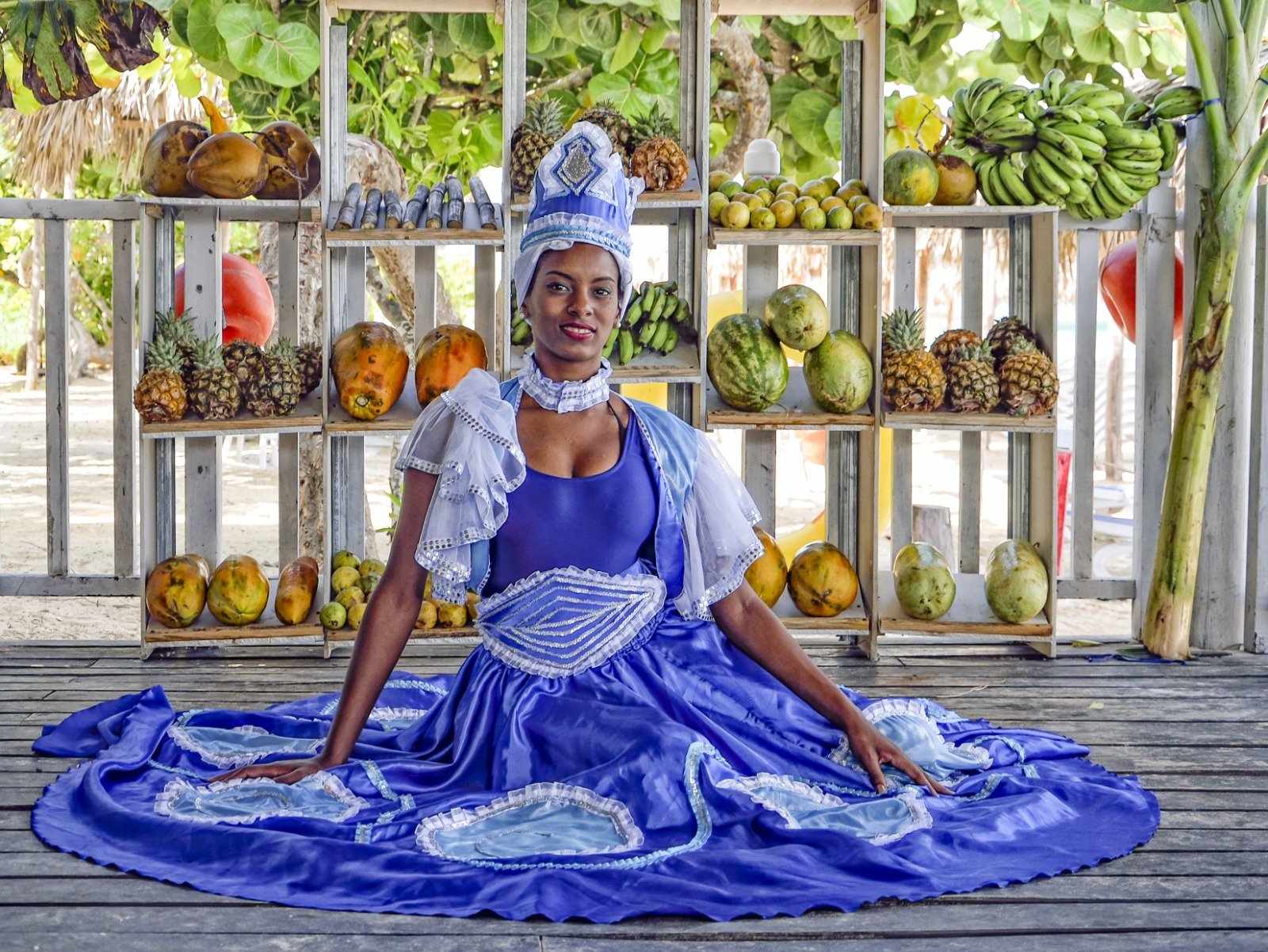 Puesto de frutas tropicales cubanas con vendedora en vestido tradicional